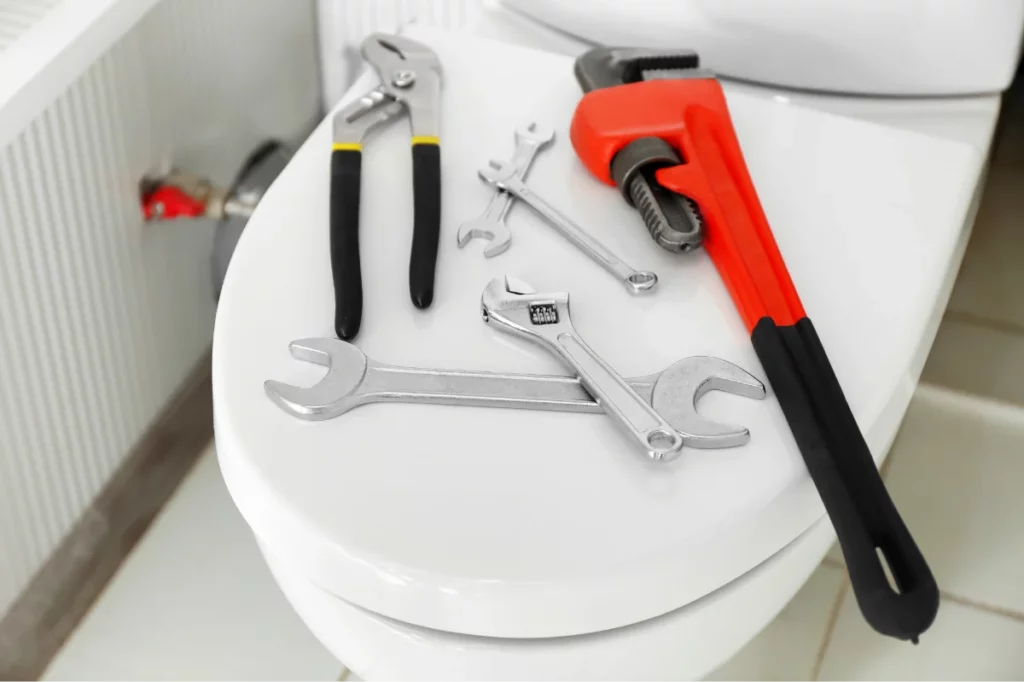 plumbing tools sitting on a closed toilet lid